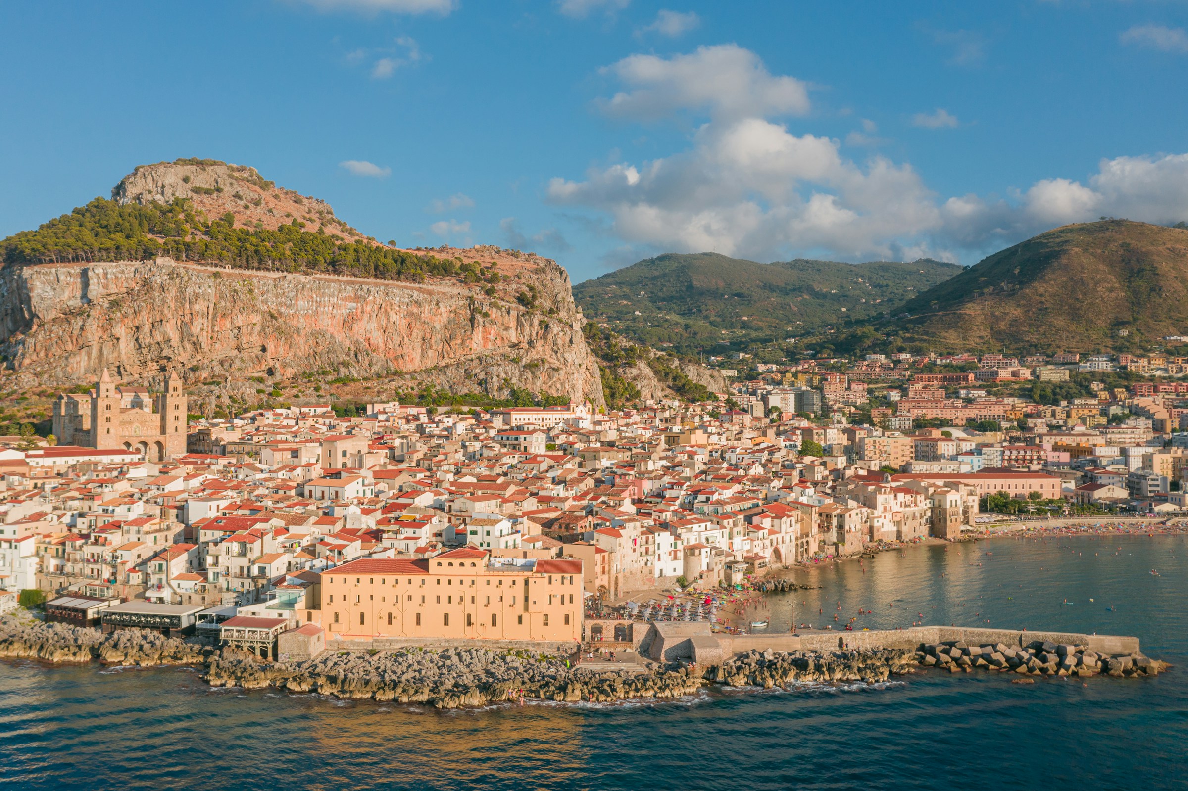 Veduta di Cefalù, con il centro storico affacciato sul mare e la Rocca alle spalle.